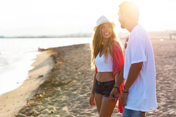 Bella giovane coppia innamorata che cammina sulla spiaggia . — Foto Stock