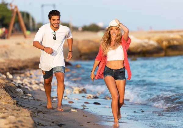 Belo jovem casal apaixonado andando na praia . — Fotografia de Stock