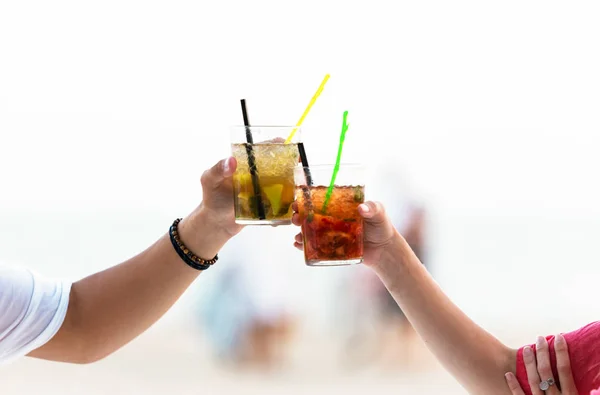 Красивая молодая пара пьет прохладительные напитки на пляже . — стоковое фото