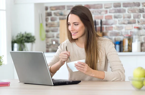 Kvinna med hennes laptop medan man äter — Stockfoto