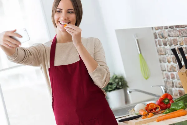 Mulher tomando selfie enquanto cozinha — Fotografia de Stock