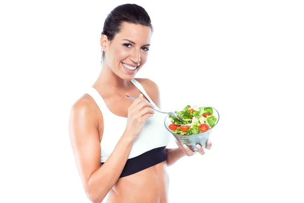 Mooie jonge vrouw salade eten op witte achtergrond. — Stockfoto
