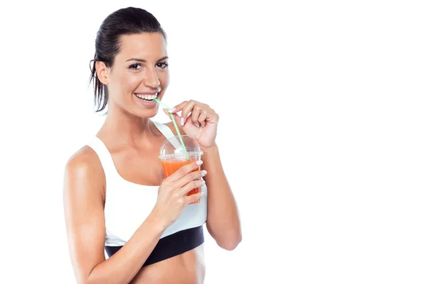 Beautiful young woman drinking detox juice over white background — Stock Photo, Image