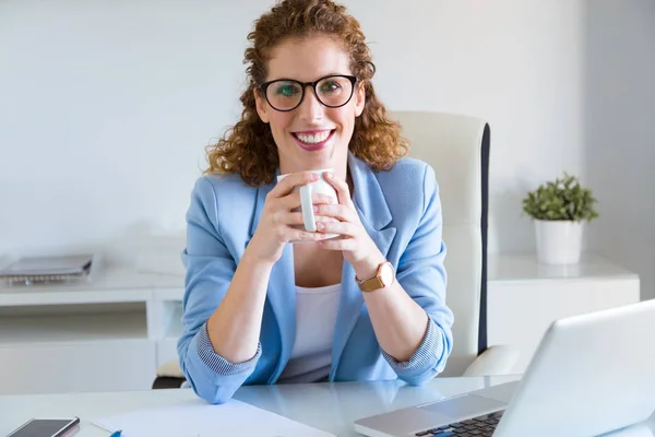 Mooie jonge zakenvrouw kijken camera in het kantoor. — Stockfoto