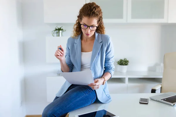 Bella donna d'affari che rivede documenti in ufficio . — Foto Stock