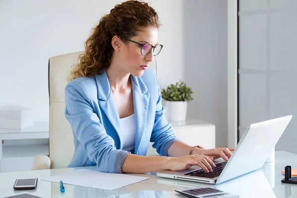 Schöne Geschäftsfrau arbeitet mit ihrem Laptop im Büro. — Stockfoto