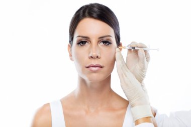 Güzel genç kadın Botox kozmetik enjeksiyon yüzüne beyaz arka plan üzerinde almak..