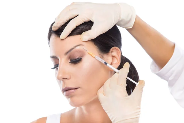 Όμορφη νεαρή γυναίκα να πάρει botox καλλυντικά ένεση στο πρόσωπό της πάνω από το λευκό φόντο. — Φωτογραφία Αρχείου