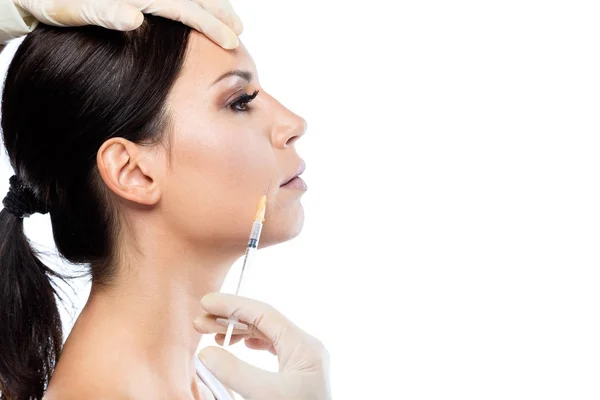 Krásná mladá žena dostává kosmetická injekce botox v její tváři nad bílým pozadím. — Stock fotografie
