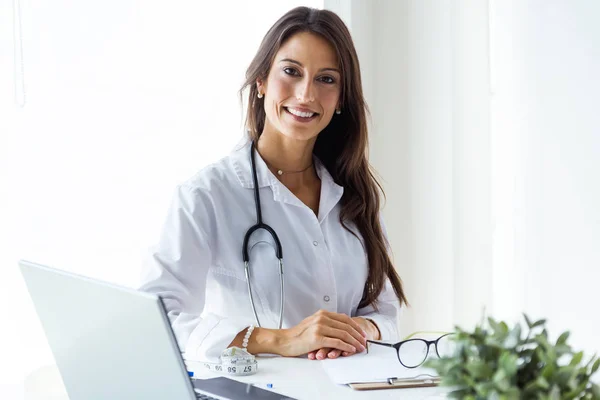 Belle jeune femme médecin regardant la caméra dans le bureau . — Photo