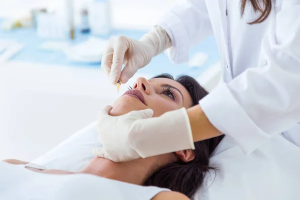 Beautiful young woman getting botox cosmetic injection in her face. — Stock Photo, Image