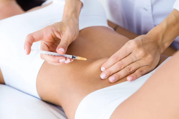 Cirujano haciendo inyección en el cuerpo femenino. Concepto de liposucción . — Foto de Stock