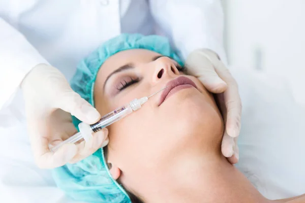 Beautiful young woman getting botox cosmetic injection in her face. — Stock Photo, Image