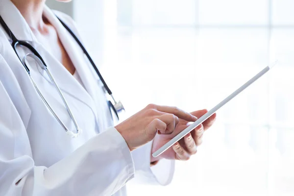 Femmina medico utilizzando il suo tablet digitale in ufficio . — Foto Stock