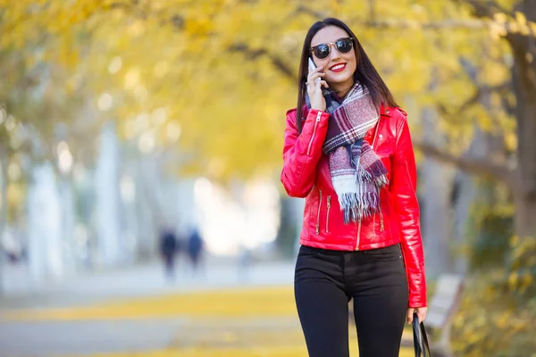 Красива молода жінка використовує свій мобільний телефон восени . — стокове фото