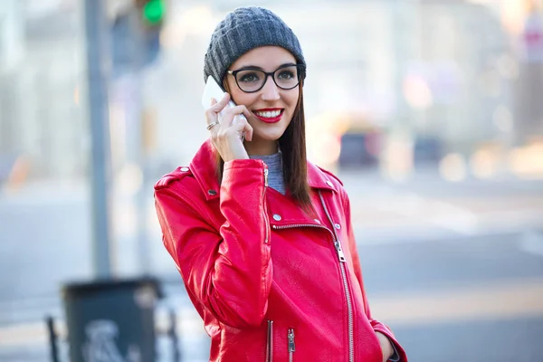 Vacker ung kvinna med hennes mobiltelefon i staden. — Stockfoto