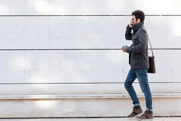 Moderne jonge man met zijn mobiele telefoon in de straat. — Stockfoto