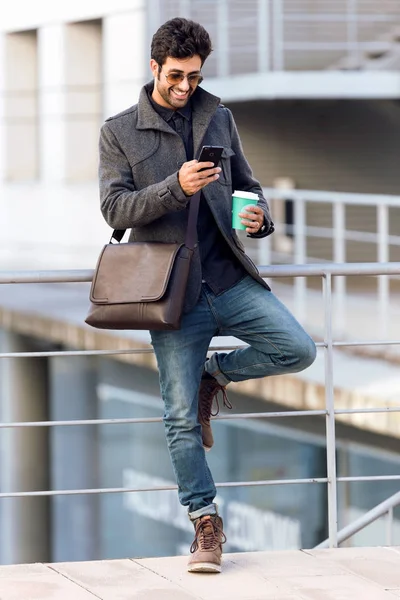 Moderner junger Mann mit seinem Handy auf der Straße. — Stockfoto