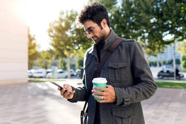 Сучасний молодий чоловік використовує свій мобільний телефон на вулиці . — стокове фото