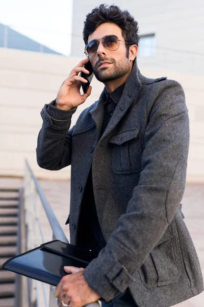 Moderno giovane uomo che utilizza il suo telefono cellulare in strada . — Foto Stock
