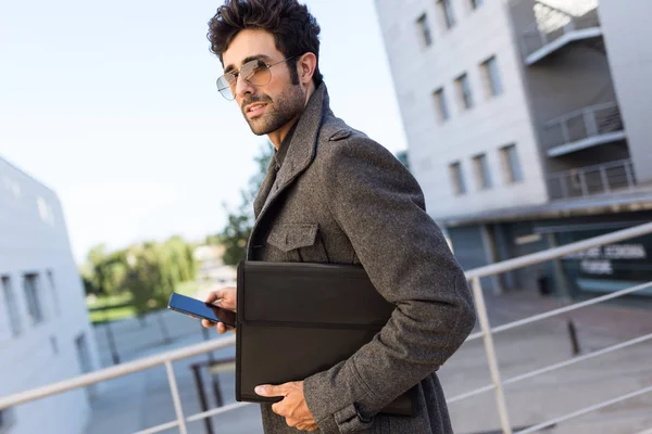 Moderne jonge man met zijn mobiele telefoon in de straat. — Stockfoto