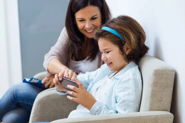 Mãe e filha usando telefone celular na sala de espera do médico . — Fotografia de Stock