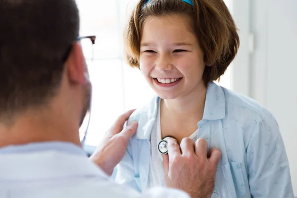 Dívka vyšetřen pediatrem v kanceláři s stetoskop. — Stock fotografie