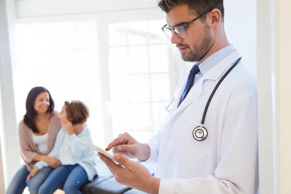 Självsäker manliga läkare använder sin digitala surfplatta på kontoret. — Stockfoto