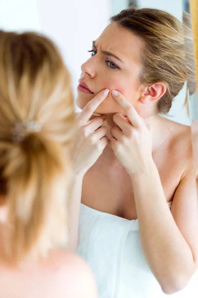 Bella giovane donna rimuovere brufolo dal suo viso in una casa bagno . — Foto Stock