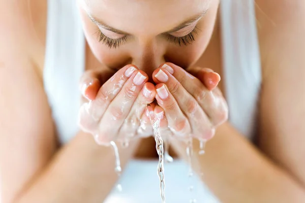 Hermosa joven lavándose la cara salpicando agua en un baño en casa. —  Fotos de Stock