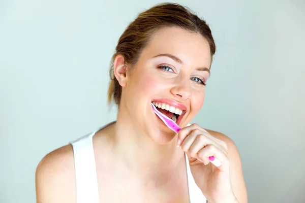 Mujer bastante joven cepillándose los dientes en el baño en casa . — Foto de Stock