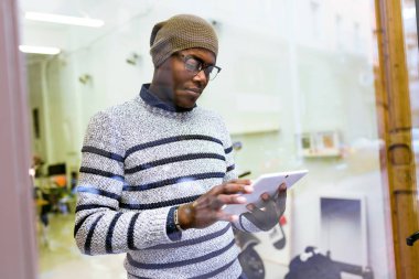 Yakışıklı genç adam onun dijital tablet evde kullanma.