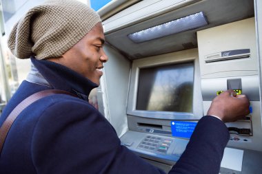 Atm kredi kartı ile nakit alarak yakışıklı genç.
