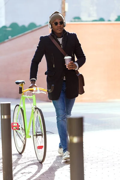 Beau jeune homme marchant avec son vélo dans la rue . — Photo