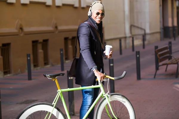 Joven guapo caminando con su bicicleta en la calle . — Foto de Stock