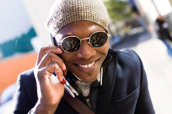 Όμορφος νεαρός άνδρας που χρησιμοποιεί το κινητό του τηλέφωνο στο δρόμο. — Φωτογραφία Αρχείου