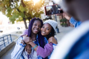 Grup üç arkadaşıyla birlikte sokakta istimal hareket eden telefon.
