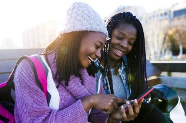 Sokakta mobil telefon kullanan iki güzel genç kadın.