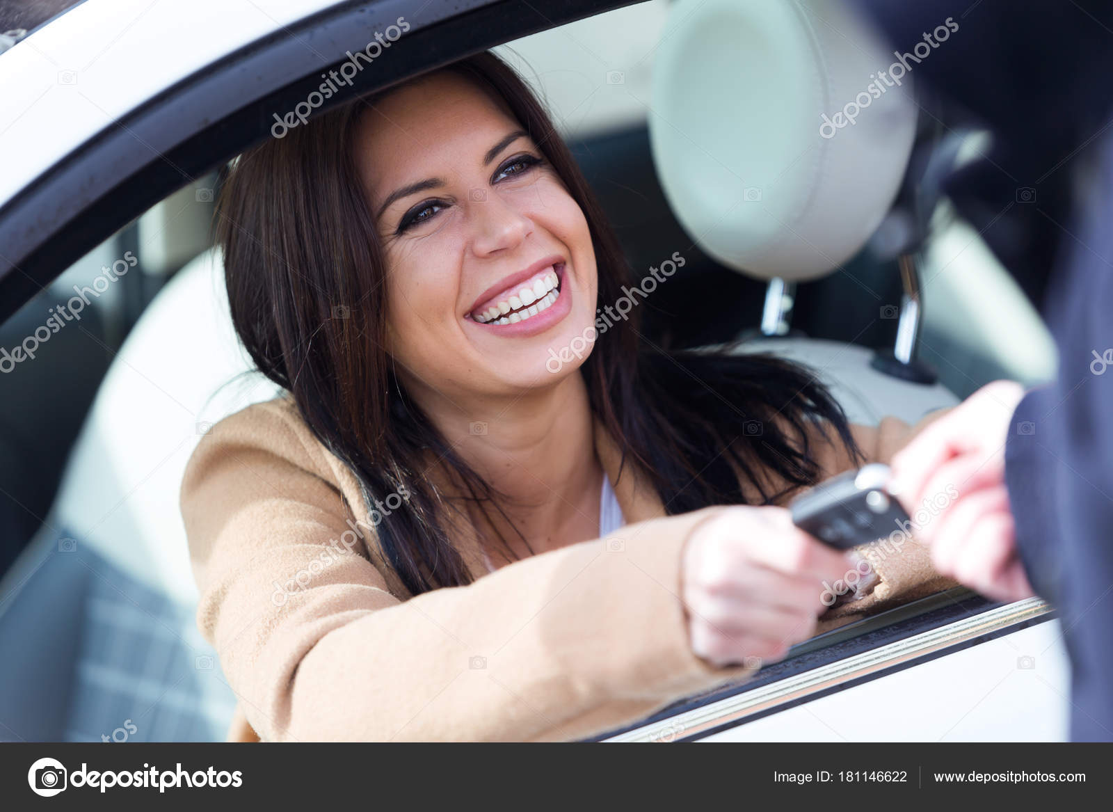 Car rental agency employee giving car keys to beautiful young woman