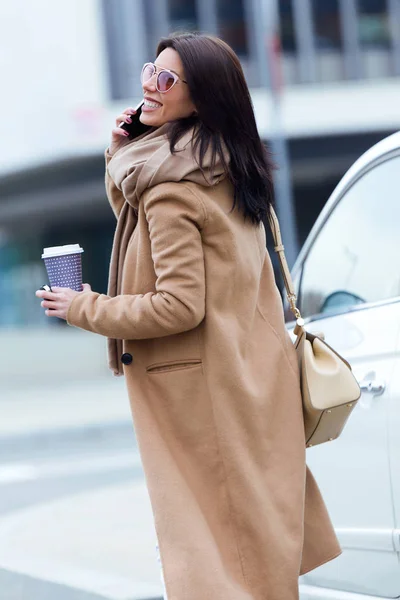 Mooie jonge vrouw met behulp van haar mobiele telefoon in de straat. — Stockfoto