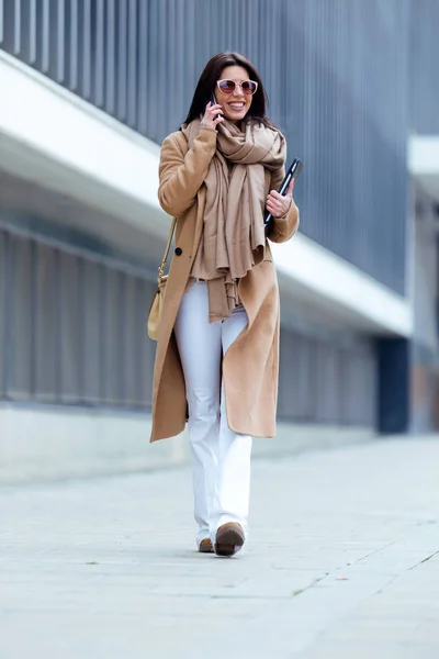 Hermosa joven usando su teléfono móvil en la calle . — Foto de Stock