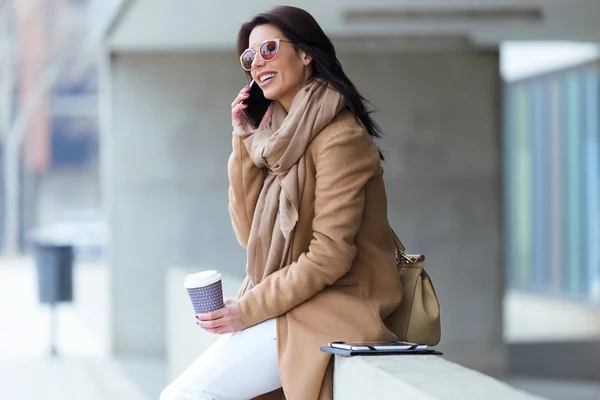 Krásná mladá žena pomocí svého mobilního telefonu na ulici. — Stock fotografie