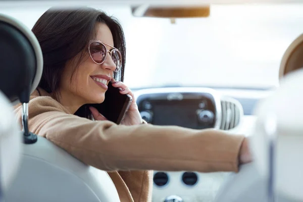 Mulher bonita usando seu telefone celular no carro . — Fotografia de Stock