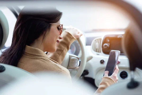 Mulher bonita usando seu telefone celular no carro . — Fotografia de Stock