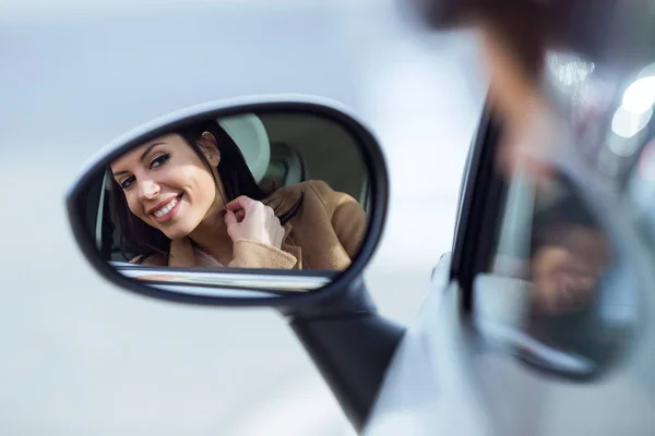 Bella giovane donna guardando nello specchio retrovisore . — Foto Stock