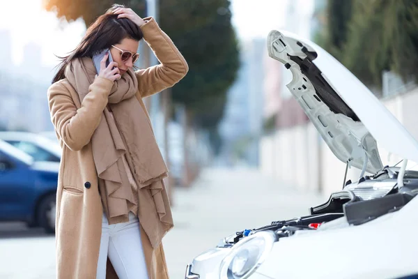 Mulher bonita usando seu telefone celular pede ajuda para o carro . — Fotografia de Stock