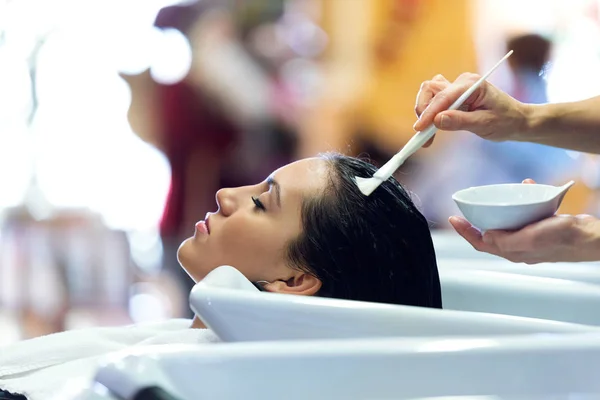 O cabeleireiro aplicando tratamento de cabelo para o cliente em um salão de beleza . — Fotografia de Stock