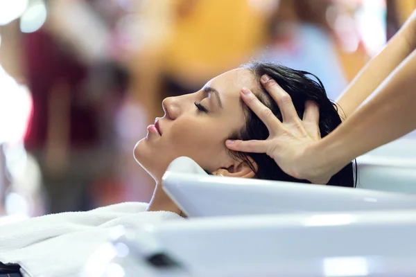 Schöne junge Frau wäscht Haare in einem Schönheitssalon. — Stockfoto