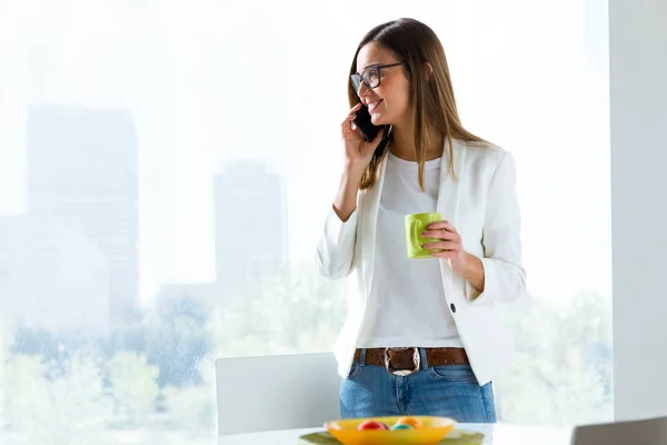 Молодая деловая женщина, пользующаяся мобильным телефоном в офисе . — стоковое фото