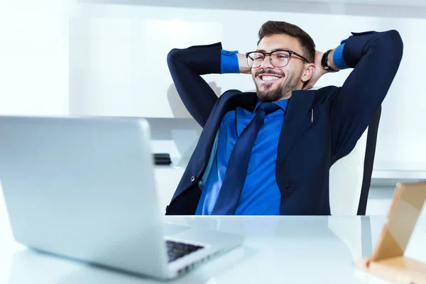 Beau jeune homme d'affaires se détendre après avoir travaillé dans le bureau . — Photo